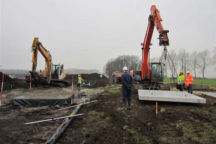 De betonplaat, waarop het cor-ten stalen beeld ""de Golf" van Mieke de Waa wordt gemonteerdl, wordt op het böok polystyreen gelegd.